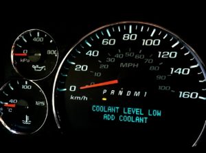 A dashboard shows a coolant warning message: 'Coolant level low - add coolant'.