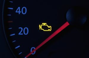 A 'check engine' light glows on a car dashboard.