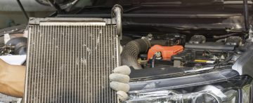 A person holding a repaired car radiator