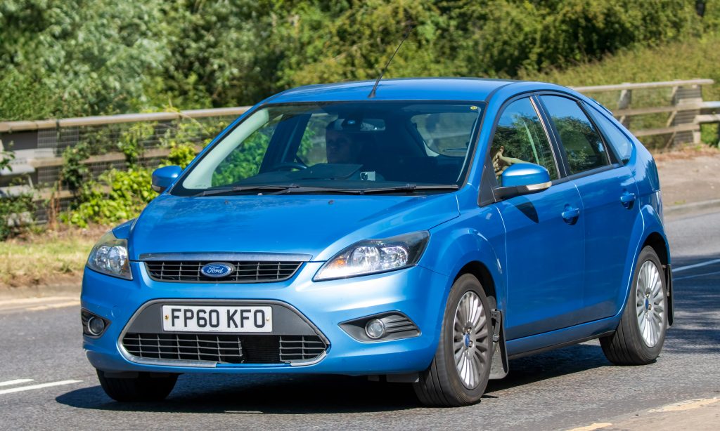 A blue Ford Focus driving on the road.