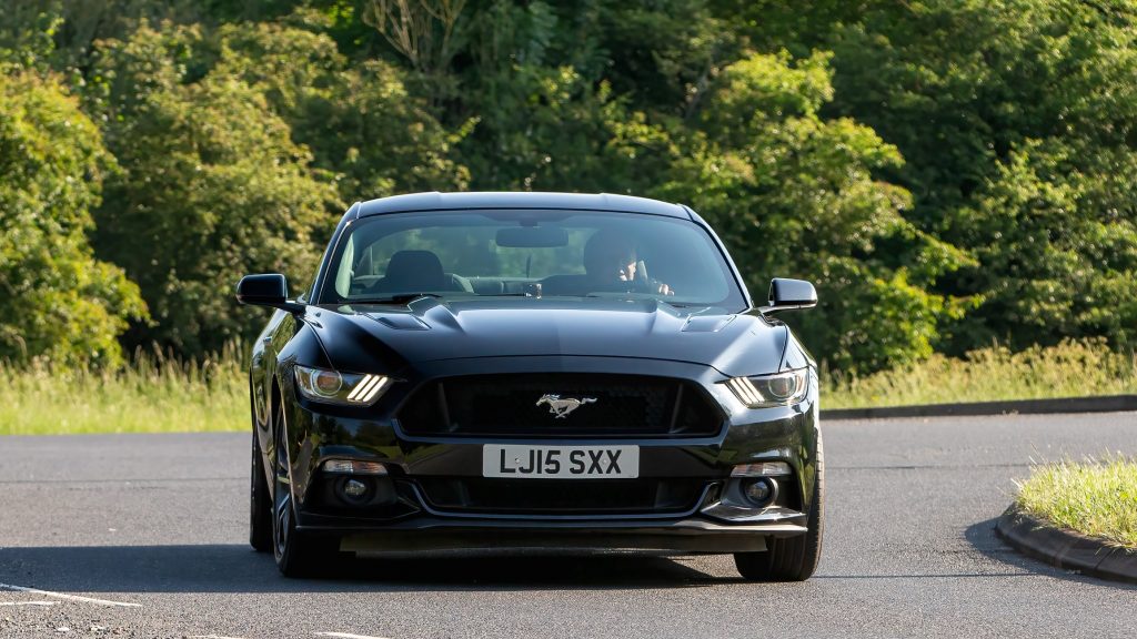 A 2015 black Ford Mustang car driving