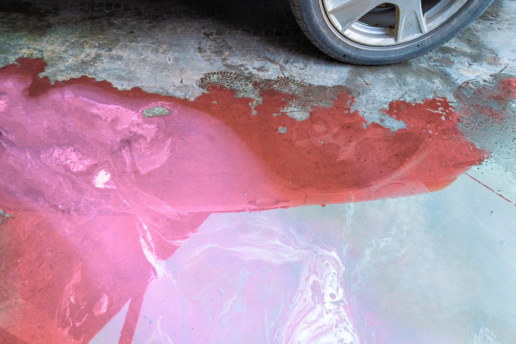 Coolant leak puddle beneath a car